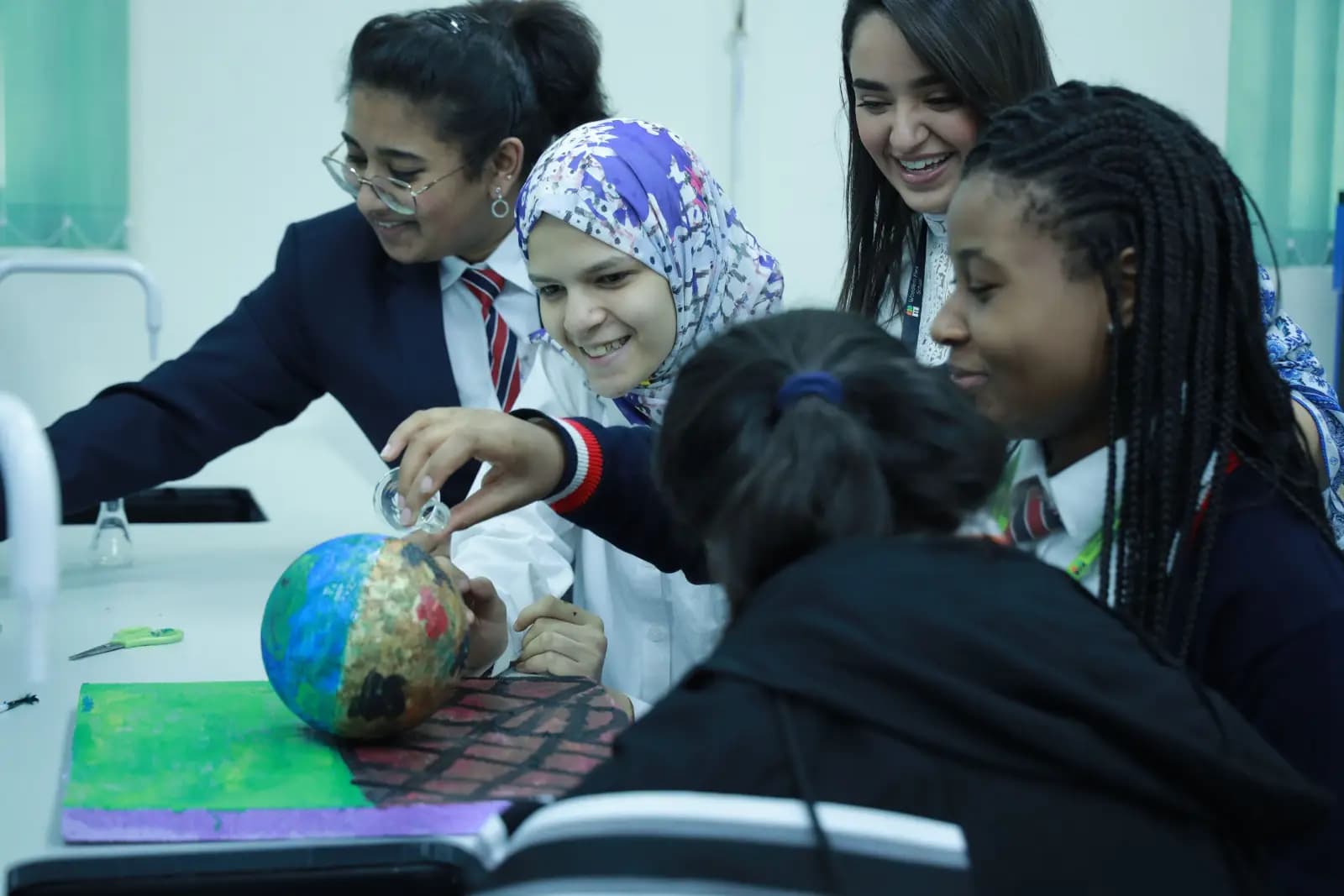 Students exploring a globe in geography class